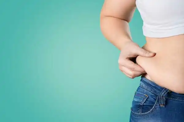 Image of woman pinching her love handles to show weight gain Burton upon Trent